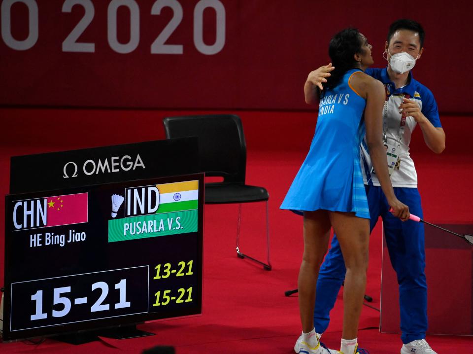 India's P. V. Sindhu (L) celebrates with a coach after beating China's He Bingjiao in their women's singles badminton bronze medal match during the Tokyo 2020 Olympic Games at the Musashino Forest Sports Plaza in Tokyo on August 1, 2021. (Photo by Alexander NEMENOV / AFP) (Photo by ALEXANDER NEMENOV/AFP via Getty Images)