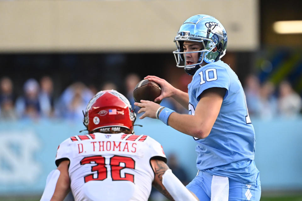 Nov 25, 2022; Chapel Hill, North Carolina, USA; North Carolina Tar Heels quarterback Drake Maye (10) looks to pass as North Carolina State Wolfpack linebacker Drake Thomas (32) defends in the first quarter at Kenan Memorial Stadium. Mandatory Credit: Bob Donnan-USA TODAY Sports