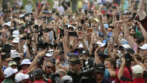 Fans fill the 18th fairway surrounding Tiger Woods and Rory McIlroy as they make their way to the green during the final round of the Tour Championship golf tournament Sunday, Sept. 23, 2018, in Atlanta. (AP Photo/John Amis)