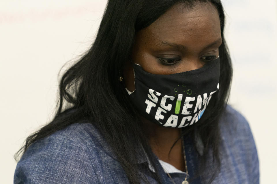 Lisa Seale wears a face mask as she teaches chemistry to 11th and 12th graders who are participating in person and remotely during the coronavirus outbreak at Roosevelt High School - Early College Studies, Thursday, Oct. 15, 2020, in Yonkers, N.Y. (AP Photo/Mary Altaffer)