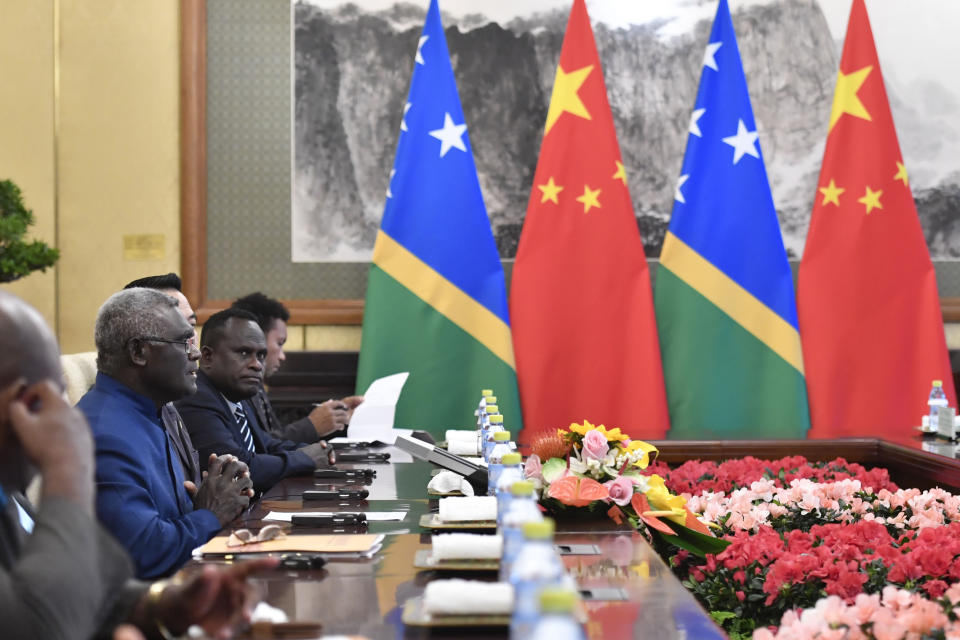 FILE - Prime Minister of the Solomon islands Manasseh Sogavare, second left, talks to Chinese President Xi Jinping, not pictured, during their meeting at the Diaoyutai State Guesthouse in Beijing, on Oct. 9, 2019. A leaked document indicates that China could boost its military presence in the Solomon Islands — including with ship visits — in a development that is raising alarm in nearby Australia and beyond. The Solomon Islands revealed on Thursday, March 24, 2022, it had signed a policing cooperation agreement with China. But more concerning to Australia was the draft text of a broader security arrangement that was leaked online. (Parker Song/Pool Photo via AP, File)