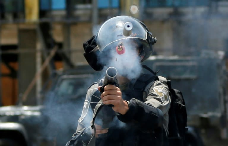 An Israeli border guard fires a tear gas canister towards Palestinian protesters during clashes near the Jewish settlement of Beit El, near the West Bank city of Ramallah, on July 24, 2017