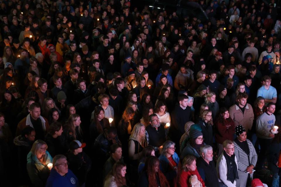 An overflow crowd watches a television screen as it broadcasts from inside the Basilica of Saints Peter and Paul during Sunday's vigil.