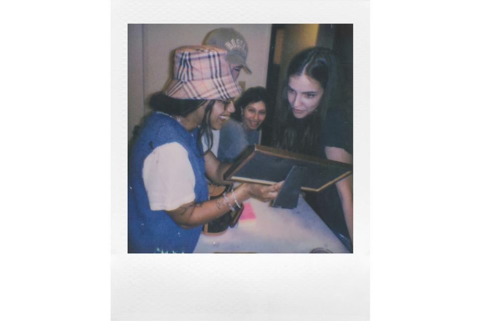 Quinn Whitney Wilson showing framed photograph to friends