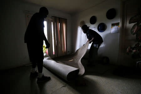 Neighbors remove flood-damaged carpet from a friend's home in the aftermath of Tropical Storm Harvey in Port Arthur, Texas, U.S. September 5, 2017. REUTERS/Jonathan Bachman