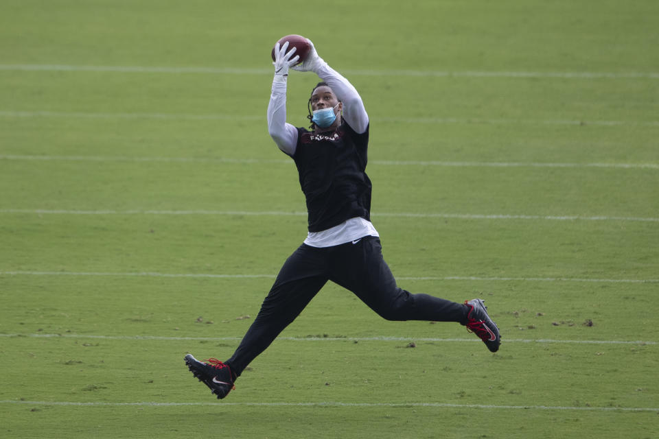 Todd Gurley leaps to grab a pass with blue face mask around his mouth.