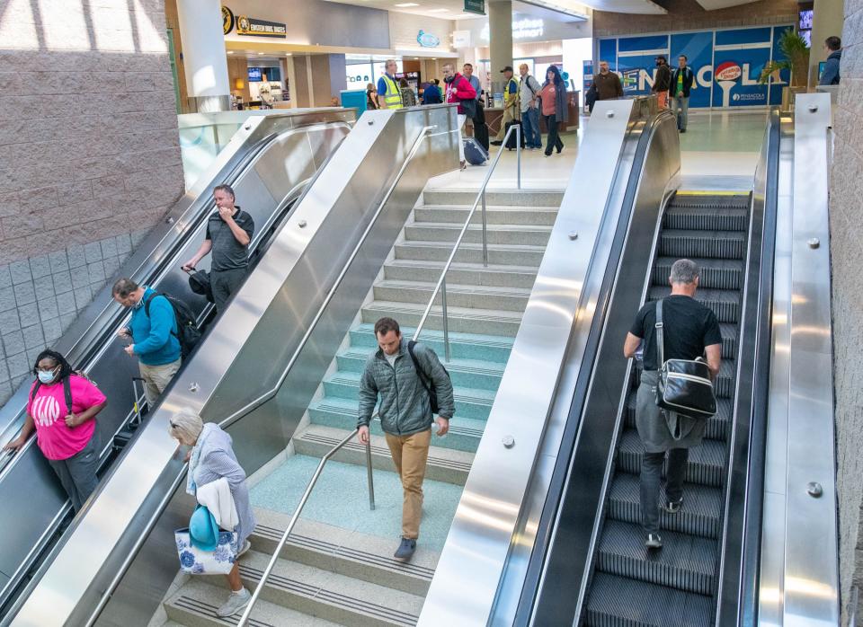 Passengers use the escalators and stairs at the Pensacola International Airport on Monday. Record-breaking numbers of travelers have come through the airport over the last few years, putting additional strain on its infrastructure. Airport officials are hoping to break ground on an expansion project in 2024 or 2025.