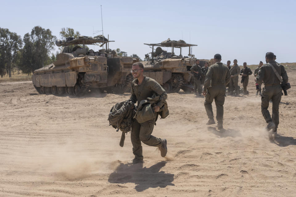 Israeli soldiers stand next to personnel carriers (APC) near the Israeli-Gaza border, in southern Israel, Monday, April 15, 2024. (AP Photo/Ohad Zwigenberg)