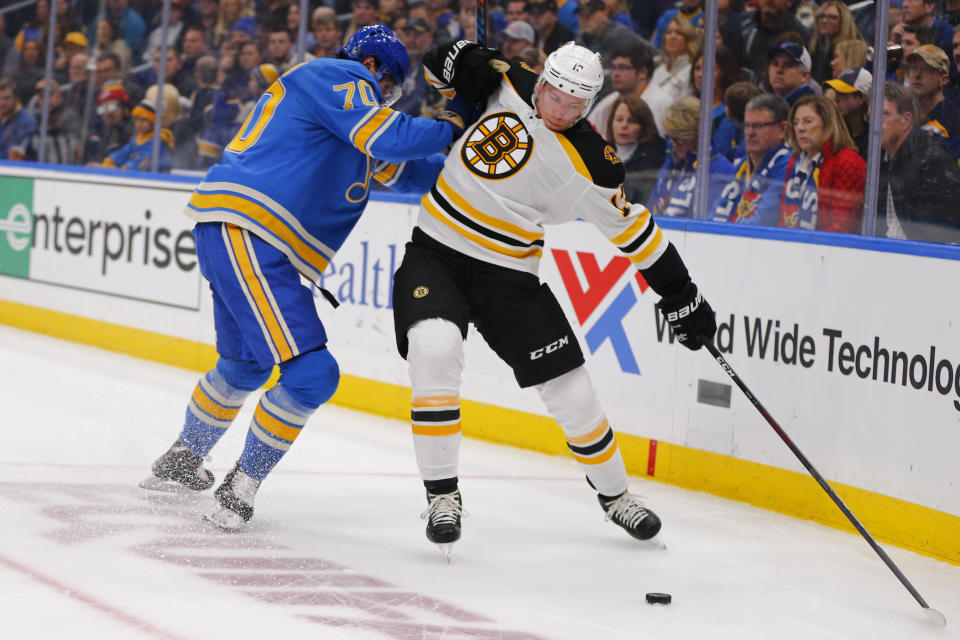 FILE - In this Feb. 23, 2019, file photo, Boston Bruins' Charlie Coyle (13) tries to avoid a check from St. Louis Blues' Oskar Sundqvist (70), of Sweden, during the first period of an NHL hockey game in St. Louis. Game 1 of the Stanley Cup finals between the Bruins and Blues is Monday, May 27. (AP Photo/Dilip Vishwanat, File)