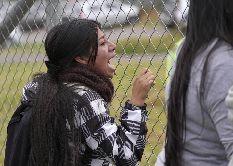 A young woman joins friends and relatives of inmates in shouting the names of their loved ones, expecting them to shout back from the inside a prison yard where they are being held after a deadly riot in Latacunga, Ecuador, Tuesday, Oct. 4, 2022. A clash between inmates armed with guns and knives inside the prison has left at least 15 people dead and 20 injured. (AP Photo/Dolores Ochoa)