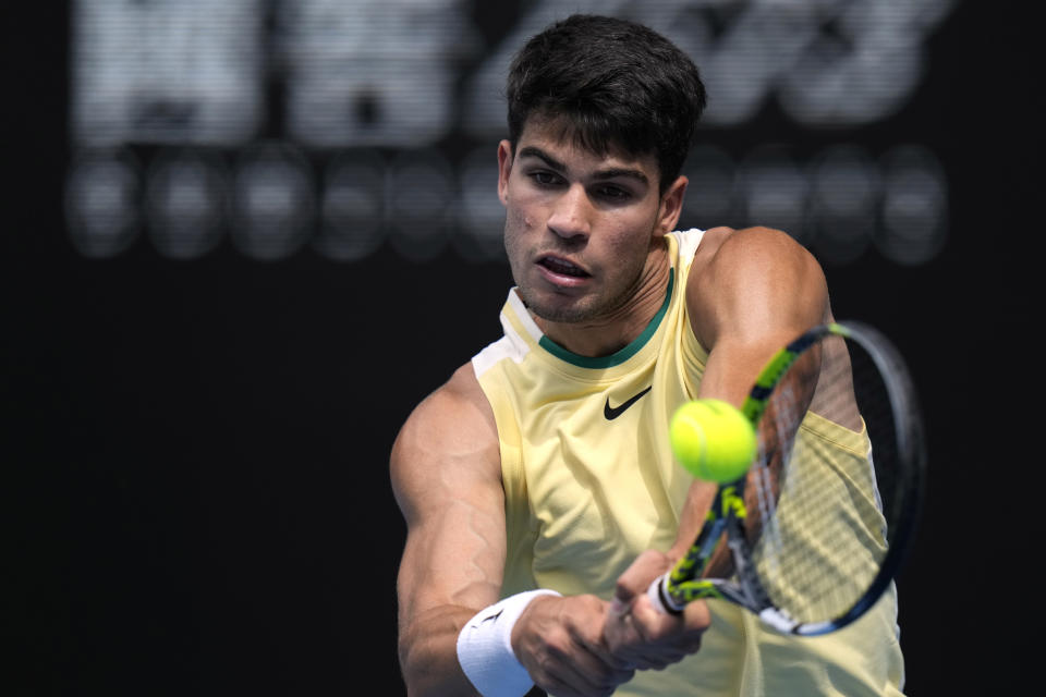 Carlos Alcaraz of Spain plays a backhand return to Shang Juncheng of China during their third round match at the Australian Open tennis championships at Melbourne Park, Melbourne, Australia, Saturday, Jan. 20, 2024. (AP Photo/Andy Wong)