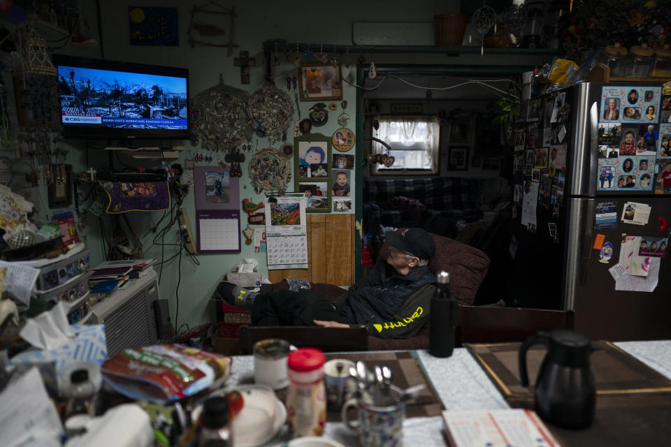 Rich Stasenko, 81, watches news of hurricane-ravaged Florida in his home in Shishmaref, Alaska, Wednesday, Oct. 5, 2022. The people of Shishmaref "are resourceful, they are resilient," said Stasenko, who arrived to Shishmaref to teach at the local school in the mid-'70s and never left. "I don't see victims here." (AP Photo/Jae C. Hong)