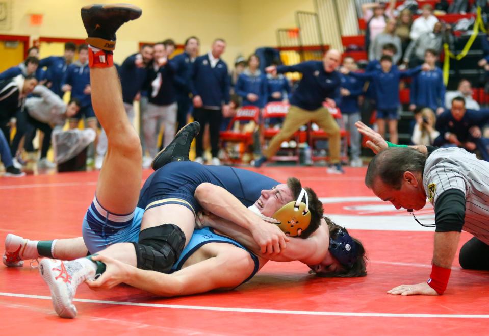 Salesianum's Colin Honaker (in dark blue singlet and headgear) gets a pin on Cape Henlopen's Braydon Cole at 144 pounds to help secure the DIAA Division I Dual Meet wrestling championship, Saturday Feb. 18, 2023 at Smyrna High School.