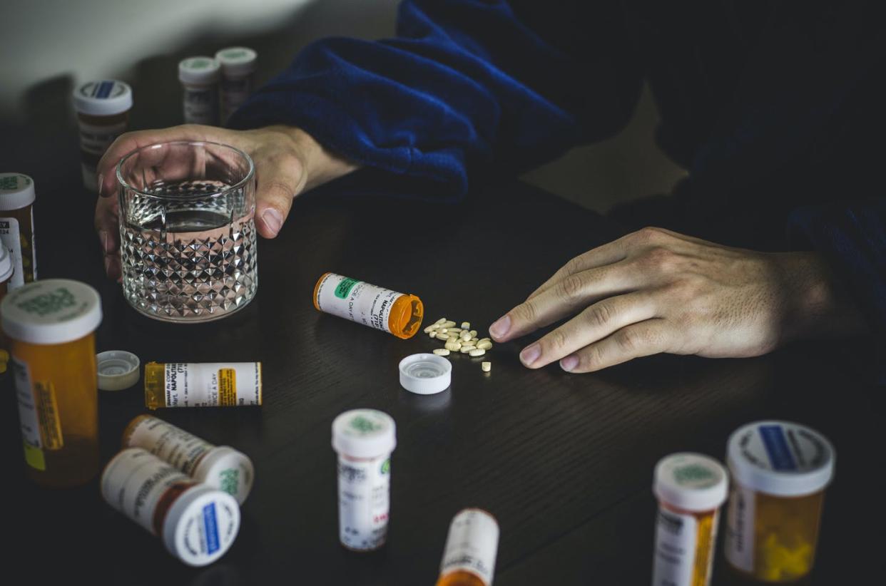 Certain SSRIs can inhibit the breakdown of opioids in the body. <a href="https://www.gettyimages.com/detail/photo/hands-of-man-in-robe-surrounded-by-prescription-royalty-free-image/588316210" rel="nofollow noopener" target="_blank" data-ylk="slk:Glasshouse Images/The Image Bank via Getty Images;elm:context_link;itc:0;sec:content-canvas" class="link ">Glasshouse Images/The Image Bank via Getty Images</a>