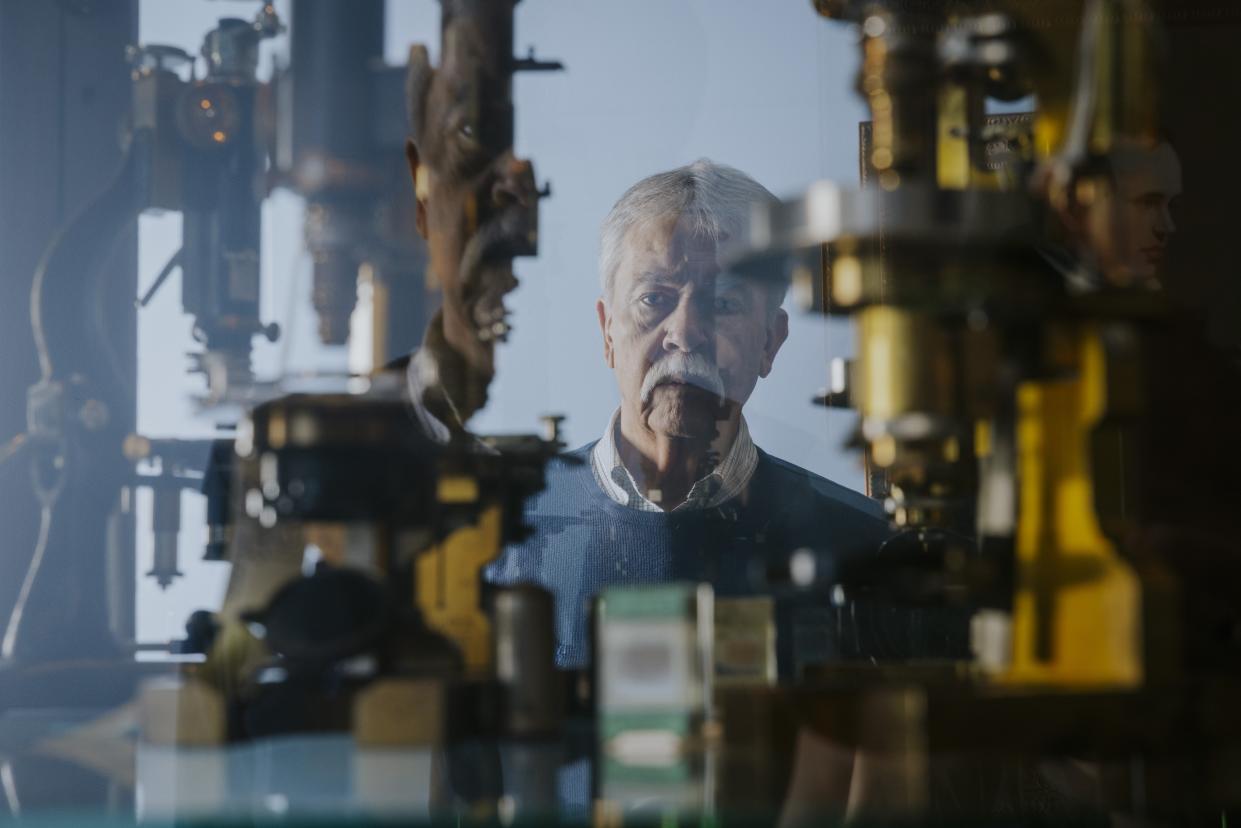 Skip Palenik is reflected in a display case of microscopes at Microtrace LLC in Elgin, Ill.  (Taylor Glascock for NBC News)