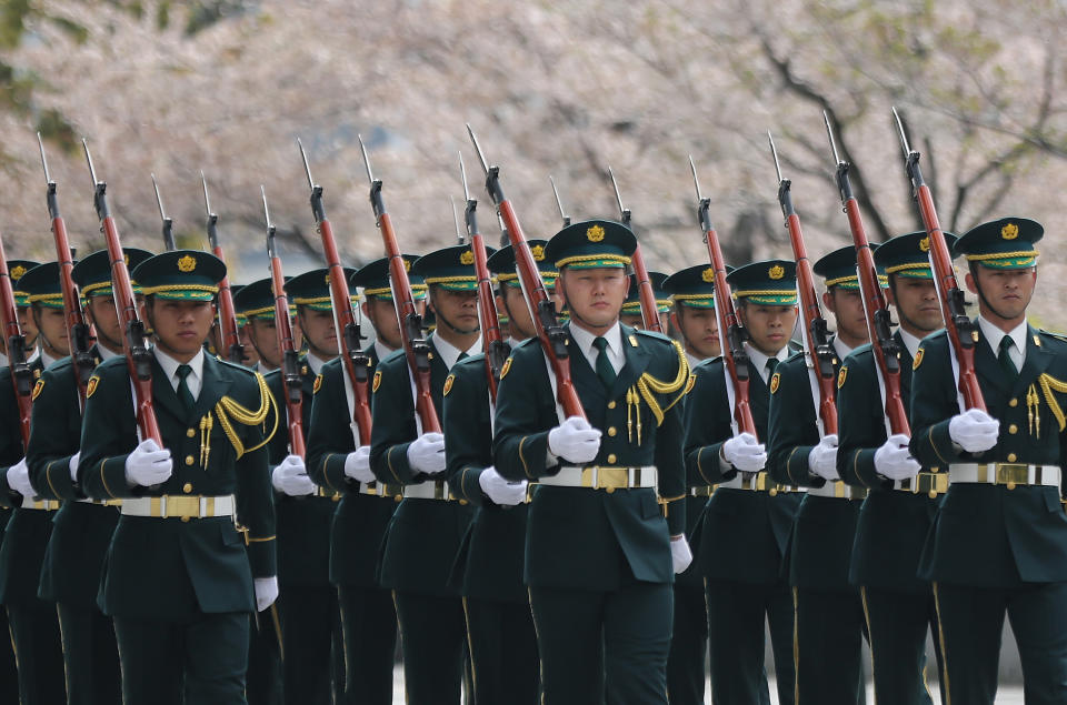 In this April 6, 2014 photo, members of a Japanese Self-Defense Forces honor guard march as they prepare to be inspected by U.S. Secretary of Defense Chuck Hagel at the Defense Ministry in Tokyo. Japan is marking the 67th anniversary of its postwar constitution on May 3, 2014 with growing debate over whether to revise the war-renouncing document. Prime Minister Shinzo Abe’s ruling conservative party has long advocated revision but been unable to sway public opinion. Now he proposes that the government reinterpret the constitution so it can loosen the reins on its military without having to win approval for constitutional change. (AP Photo/Eugene Hoshiko, Pool)