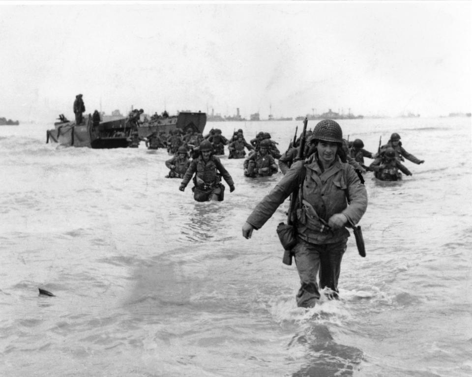 FILE - U.S. infantrymen wade through the surf as they land at Normandy in the days following the Allies' June 1944, D-Day invasion of occupied France. (AP Photo/Bert Brandt, File)
