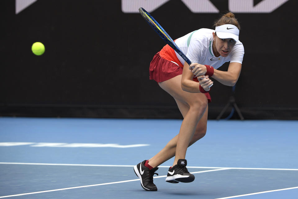 Belinda Bencic of Switzerland plays a backhand return to Kristina Mladenovic of France during their first round match at the Australian Open tennis championships in Melbourne, Australia, Monday, Jan. 17, 2022. (AP Photo/Andrew Brownbill)