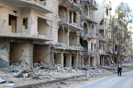 A man walks past damaged buildings in the rebel held besieged al-Sukkari neighbourhood of Aleppo, Syria October 19, 2016. REUTERS/Abdalrhman Ismail