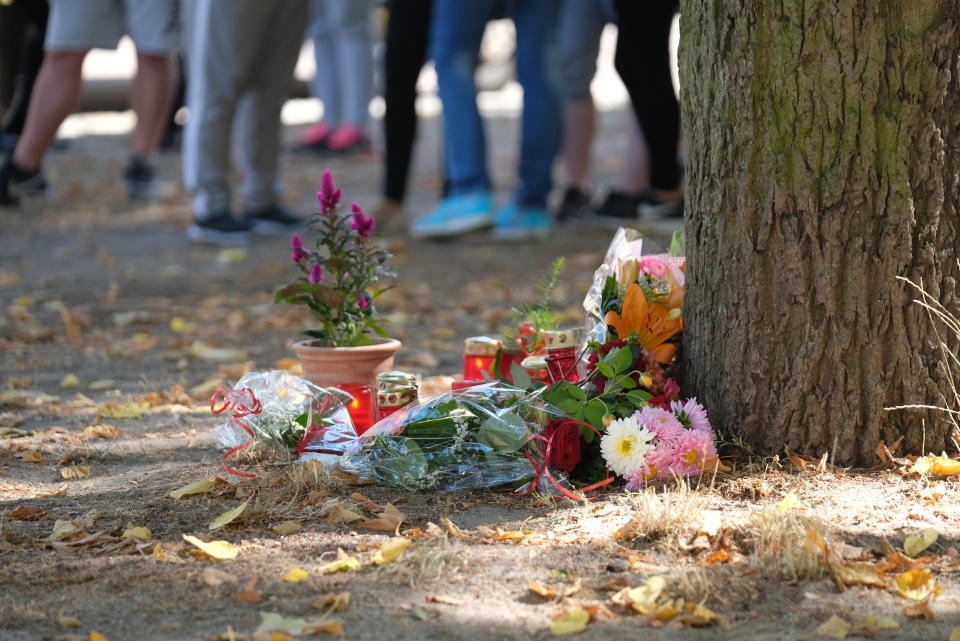 Flowers and candles sit at the scene of an altercation in Koethen, Germany, Sunday, Sept. 9, 2018. A 22-year-old man died in a dispute between two groups of men in Koethen. Two Afghan citizens were arrested in the night to Sunday because of the initial suspicion of a homicide, as police and public prosecutor's office in Saxony-Anhalt reported. (Sebastian Willnow/dpa via AP)