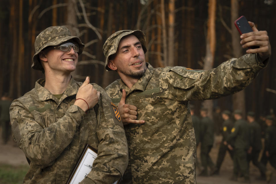 Newly recruited soldiers of the 3rd assault brigade take selfie to mark the end of their training at a military base close to Kyiv, Ukraine, Monday, Sept. 25, 2023. As the third year of war begins, the most sensitive and urgent challenge pressing on Ukraine is whether it can muster enough new soldiers to repel – and eventually drive out – an enemy with far more fighters at its disposal. (AP Photo/Efrem Lukatsky)