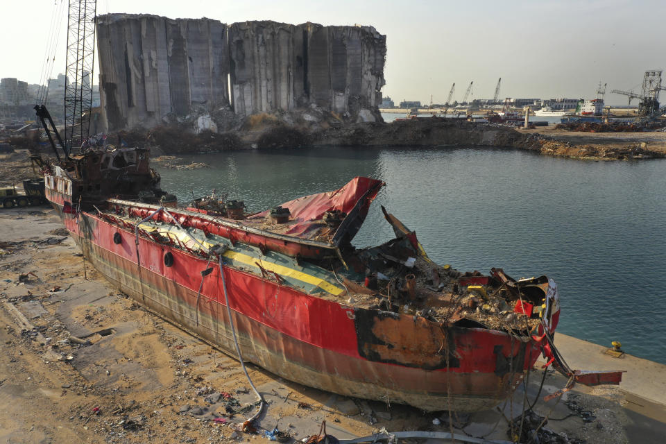 FILE - In this Dec. 2, 2020 file photo, a destroyed ship lies near towering grain silos gutted in the massive August explosion at the Beirut port that claimed the lives of more than 200 people, in Beirut, Lebanon. On Friday April 9, 2021, a delegation representing private German companies met Lebanese officials this week and briefed them on a multi-billion dollar study to rebuild the port of Beirut and surrounding neighborhoods that were destroyed by a massive blast last year. (AP Photo/Hussein Malla, File)