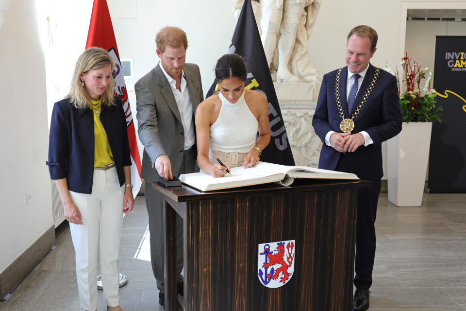 Prince Harry and Meghan Markle sign the golden book at the town hall during the Invictus Games Dusseldorf