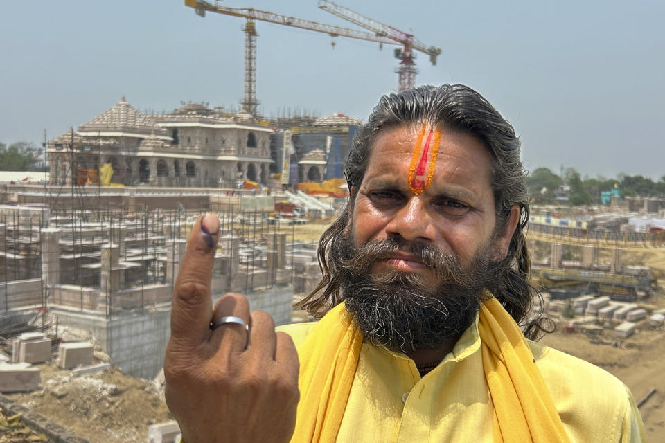 An Indian Hindu holy man who voted in the morning displays ink mark on his finger in front of the temple of Hindu god Ram during the fifth round of multi-phase national elections in Ayodhya, India, Monday, May 20, 2024. Indian Prime Minister Narendra Modi’s party, which has hailed the opening of the temple as the ruling government’s crowning achievement, is hoping it will help catapult the prime minister to a record third successive term. (AP Photo/Rajesh Kumar Singh)