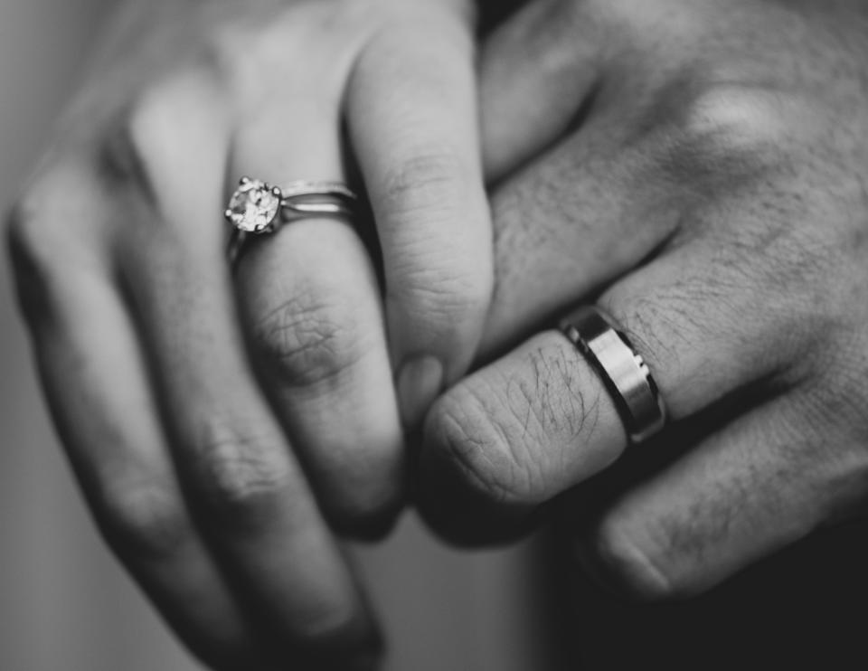 Two hands holding each other with wedding rings on their fingers