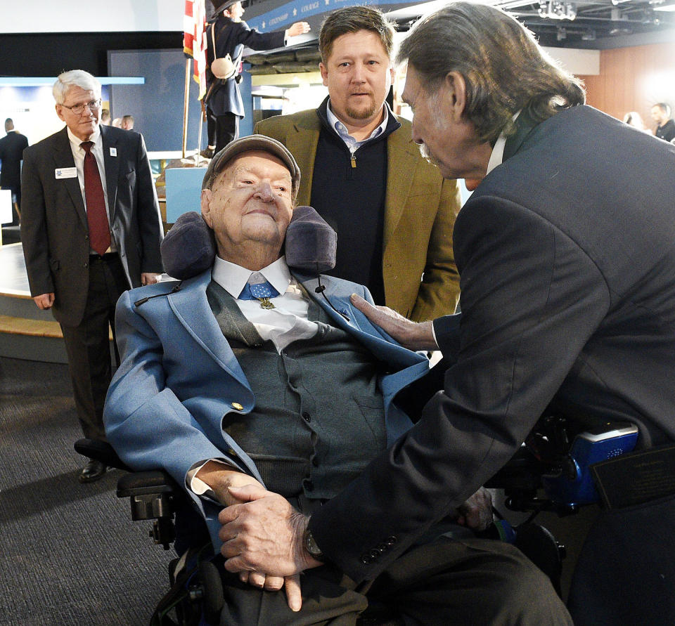 Charles Coolidge is greeted by Desmond Doss Jr., right, while Center Executive Director Keith Hardison and Mr. Coolidge's grandson, J.C. Coolidge look on, during a dedication ceremony at The Charles H. Coolidge National of Medal of Honor Heritage Center on Saturday, February 22, 2020., in Chattanooga, Tenn. Tennessee Metal of Honor recipient Charles H. Coolidge has died at age 99. The Congressional Medal of Honor Society announced in a statement that Coolidge died Tuesday, April 6, 2021, in Chattanooga. (Robin Rudd/Chattanooga Times Free Press via AP)