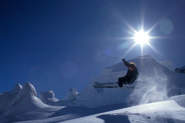 Dramatic image of an extreme lone skier off piste in mid air in the snowfields high above Chamonix in the French Alps