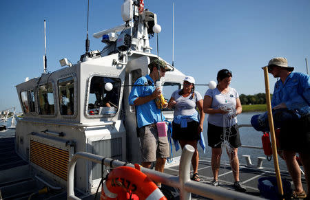 College of Charleston volunteers Sam Fink, (from left) Cynthia Hall, Dr. Cassandra Runyon and Robert Moody, prepare equipment before a balloon test launch for the Space Grant Ballooning Project, in preparations for Monday's solar eclipse on board a US Coast Guard response boat in Charleston, South Carolina, U.S. August 17, 2017. Location coordinates for this image are 32°46'25" N 79°56'37" W. REUTERS/Randall Hill