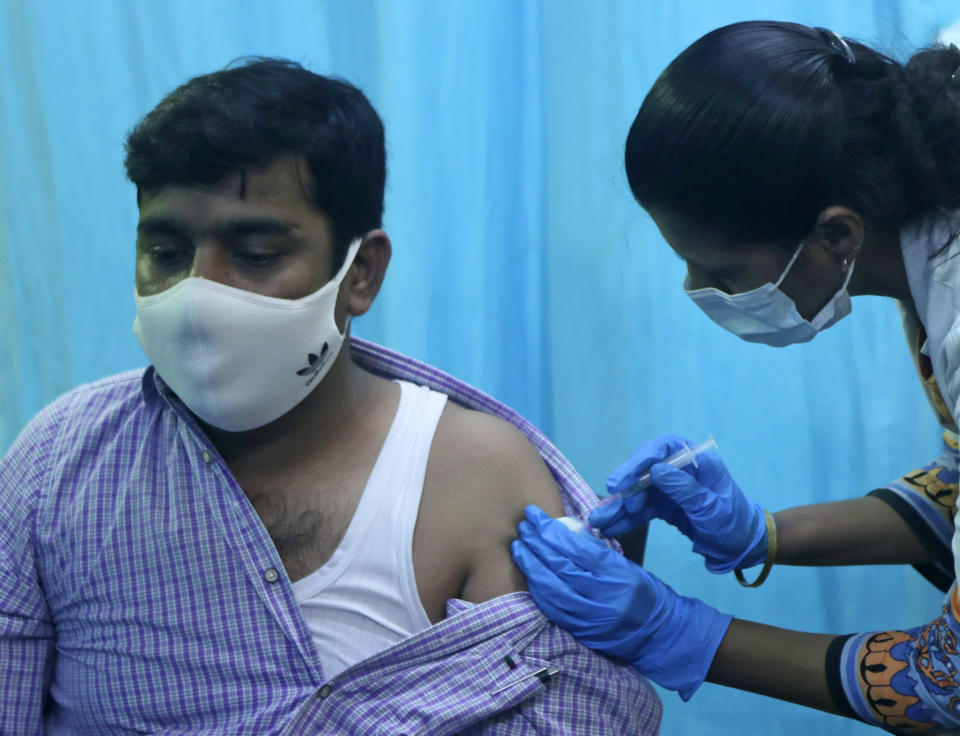 A health worker inoculates a school teacher Mohammed Haseeb Khan with the vaccine for COVID-19 during a special drive for teachers and students in Mumbai, India, Tuesday, Sept. 28, 2021. (AP Photo/Rajanish kakade)