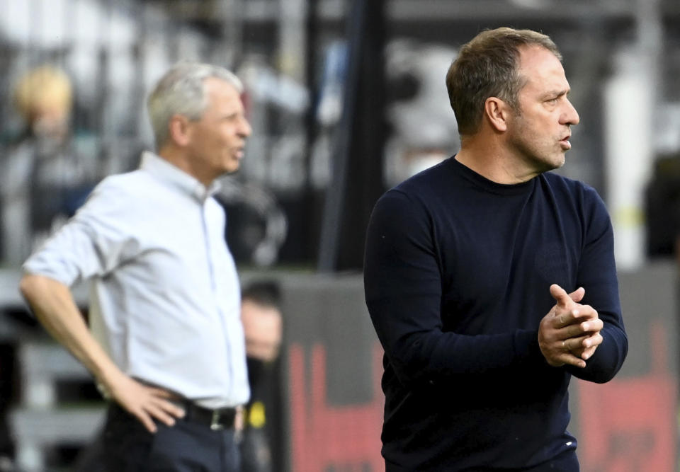 Dortmund's head coach Lucien Favre, left and Munich's head coach Hansi Flick, right, attend the German Bundesliga soccer match between Borussia Dortmund and FC Bayern Munich in Dortmund, Germany, Tuesday, May 26, 2020. The German Bundesliga is the world's first major soccer league to resume after a two-month suspension because of the coronavirus pandemic. (Federico Gambarini/DPA via AP, Pool)