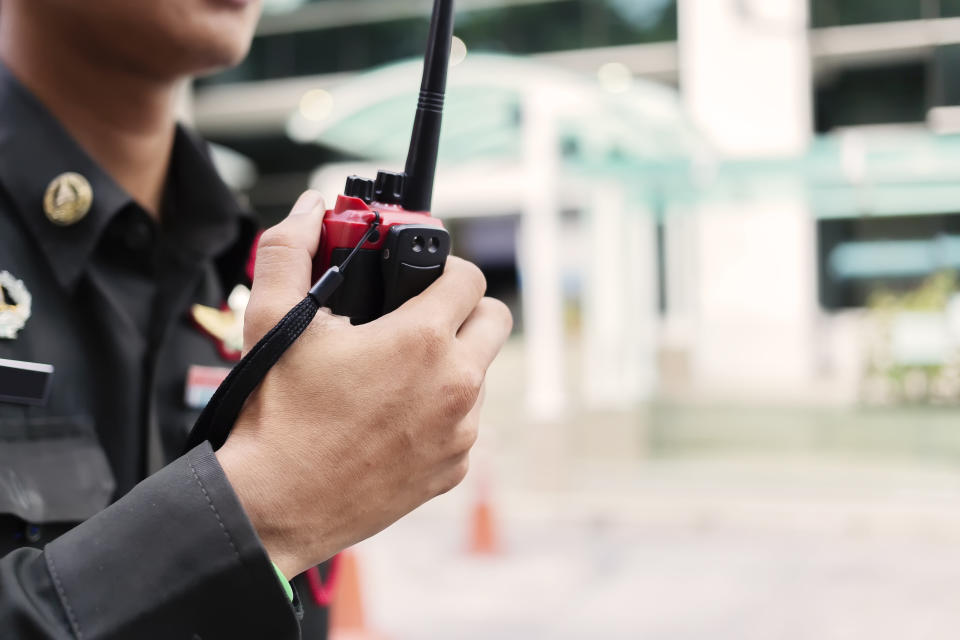 Security guard uses radio communication for facilitate traffic. Traffic Officers use walkie talkie to maintain order in the parking lot in Thailand.