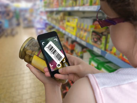 Woman scanning jar in grocery store
