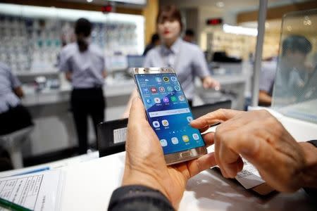 A customer uses his Samsung Electronics' Galaxy Note 7 as he waits for an exchange at company's headquarters in Seoul, South Korea, October 13, 2016. REUTERS/Kim Hong-Ji