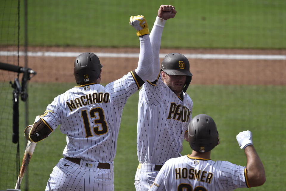 San Diego Padres' Wil Myers, back right, celebrates with Manny Machado after a solo home run during the eighth inning of the team's baseball game against the San Francisco Giants in San Diego, Wednesday, April 7, 2021. (AP Photo/Kelvin Kuo)