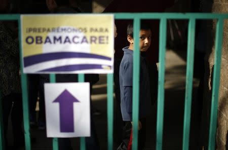 A boy waits in line at a health insurance enrollment event in Cudahy, California March 27, 2014. REUTERS/Lucy Nicholson