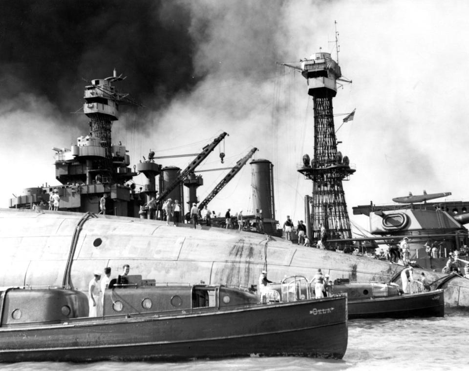 Rescue teams at work on the capsized hull of USS Oklahoma (BB-37), seeking crew members trapped inside, 7 December 1941. The starboard bilge keel is visible at the top of the upturned hull. Officers' Motor Boats from Oklahoma and USS Argonne (AG-31) are in the foreground. USS Maryland (BB-46) is in the background. Official U.S. Navy Photograph, now in the collections of the National Archives.