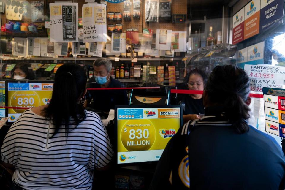 Personas compran boletos de la lotería Mega Millions en Blue Bird Liquor en Hawthorne, California, el martes 26 de julio de 2022.