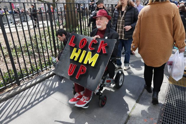 A man holds a sign reading 