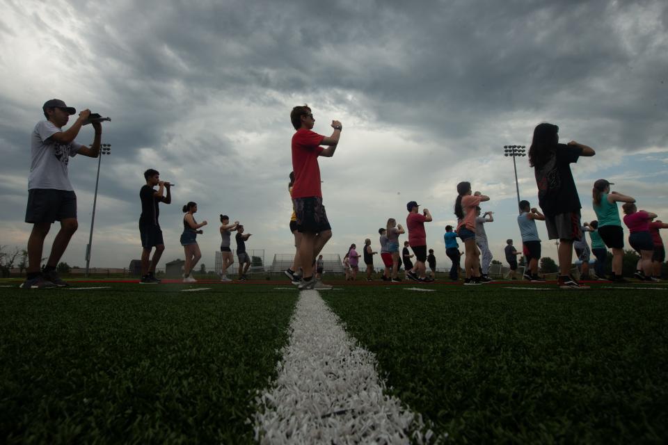 The Emporia High School marching band practices movements on its football field without instruments Thursday morning. Fewer students are enrolling in band, orchestra and other performing arts in high schools after the COVID pandemic.