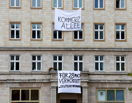 Banners hang from an apartment block on Karl Marx Allee in Berlin, Germany, November 20, 2018, to protest against plans to sell flats on a boulevard of imposing Stalinist architecture that was one of the flagship building projects of the former German Democratic Republic after World War Two. Banners read "Capitalist Avenue - flogged to Deutsche Wohnen for 28 Million". REUTERS/Joachim Herrmann