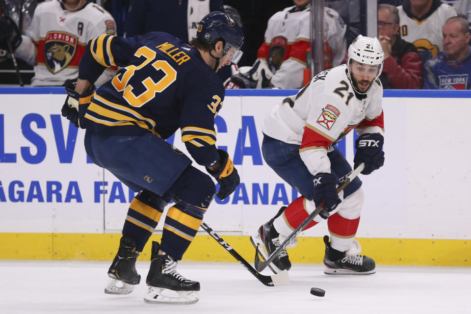 Buffalo Sabres defenseman Colin Miller (33) and Florida Panthers forward Vincent Trocheck (21) battle for the puck during the second period of an NHL hockey game Saturday, Jan. 4, 2020, in Buffalo, N.Y. (AP Photo/Jeffrey T. Barnes)