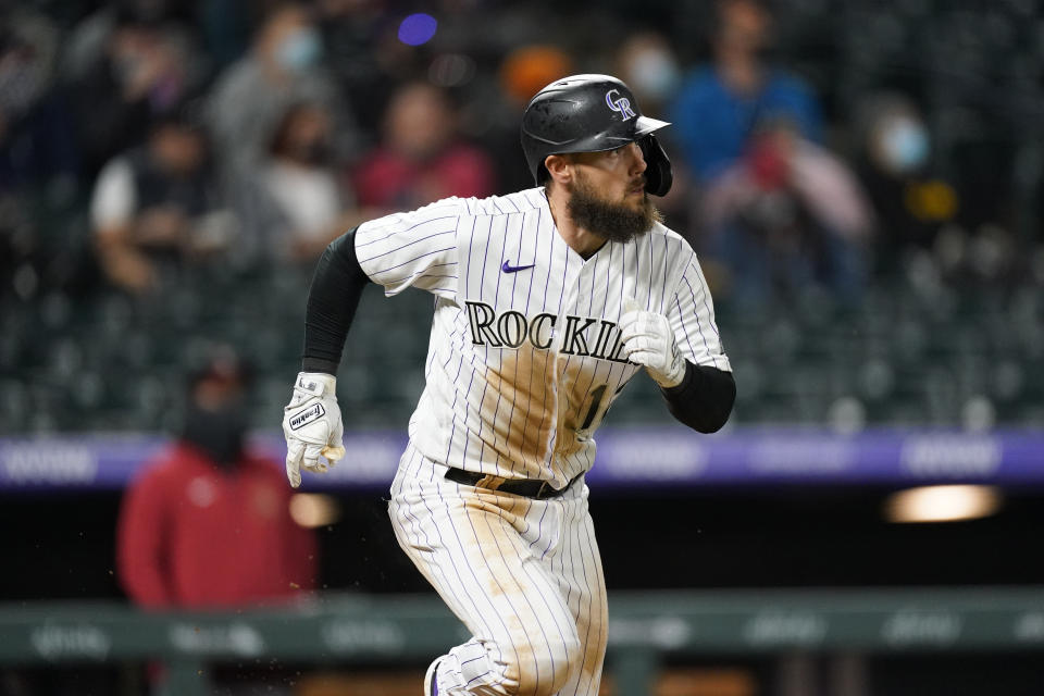 Colorado Rockies' Chris Owings follows the flight of his RBI-double off Arizona Diamondbacks starting pitcher Madison Bumgarner in the fourth inning of a baseball game Wednesday, April 7, 2021, in Denver. (AP Photo/David Zalubowski)