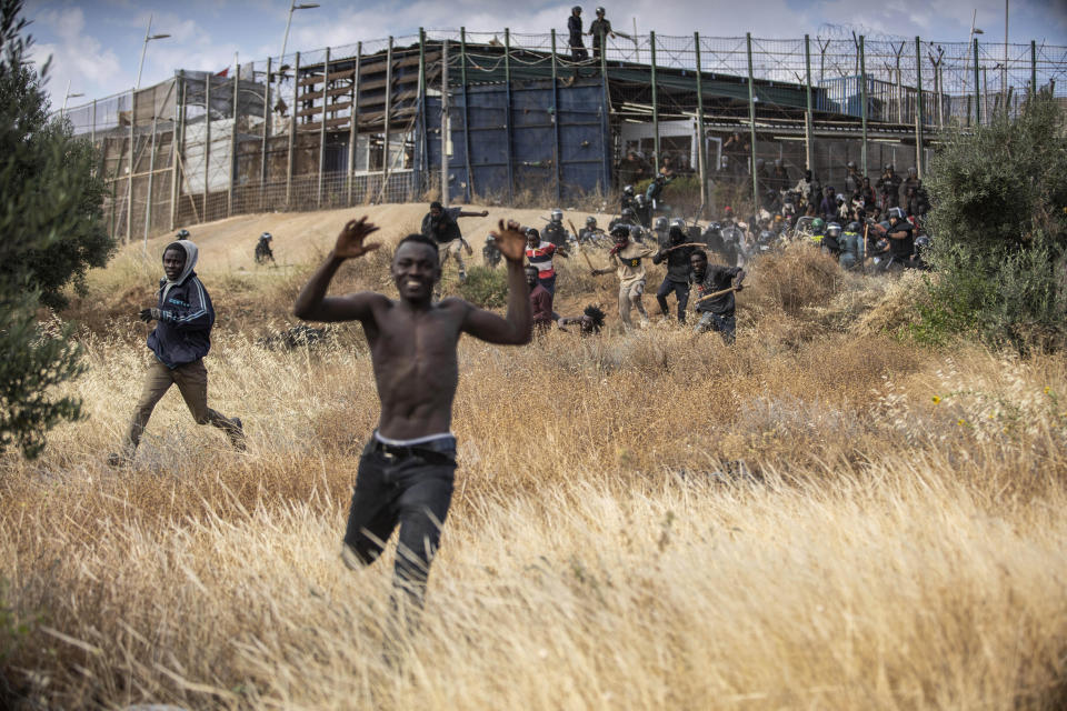 Migrants run on Spanish soil after crossing the fences separating the Spanish enclave of Melilla from Morocco in Melilla, Spain, Friday, June 24, 2022. Dozens of migrants stormed the border crossing between Morocco and the Spanish enclave city of Melilla on Friday in what is the first such incursion since Spain and Morocco mended diplomatic relations last month. (AP Photo/Javier Bernardo)