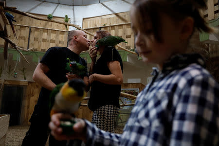 Miner Krzysztof Zawisza, 32, kisses his wife Magdalena, 31, as their daughter Zuzanna, 8, plays with a parrot during a family trip to a parrot garden, in Katowice, Poland, November 23, 2018. REUTERS/Kacper Pempel