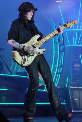 <p>Kevin Mazur/Getty</p> Mick Mars performs onstage during the Stadium Tour at Nationals Park on June 22, 2022 in Washington, D.C.