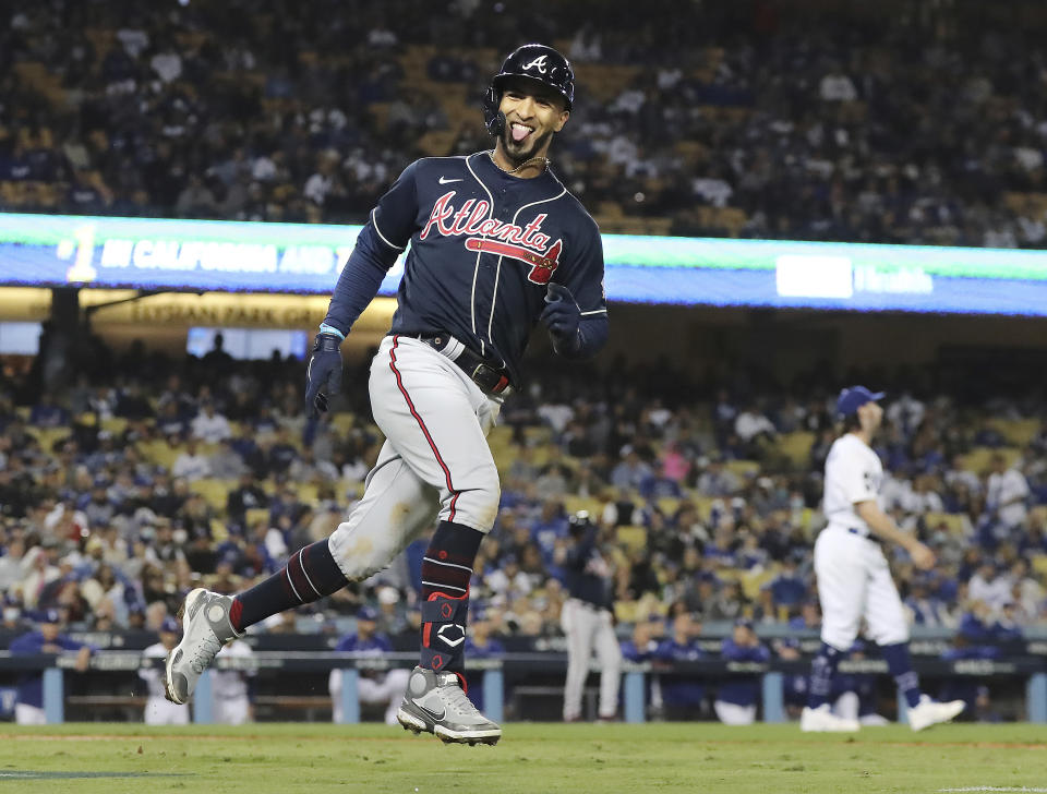 Atlanta Braves' Eddie Rosario reacts to his three-run home run in the ninth inning off Los Angeles Dodgers pitcher Tony Gonsolin, right, during Game 4 of the baseball NL Championship Series, Wednesday, Oct. 20, 2021, in Los Angeles. (Curtis Compton/Atlanta Journal-Constitution via AP)